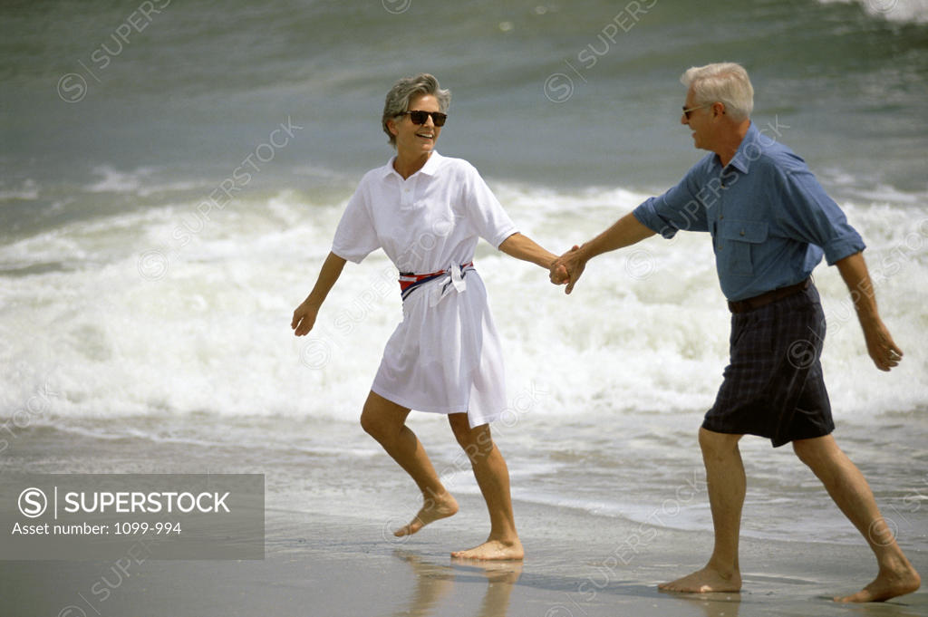 Stock Photo: 1099-994 Senior couple holding hands on the beach