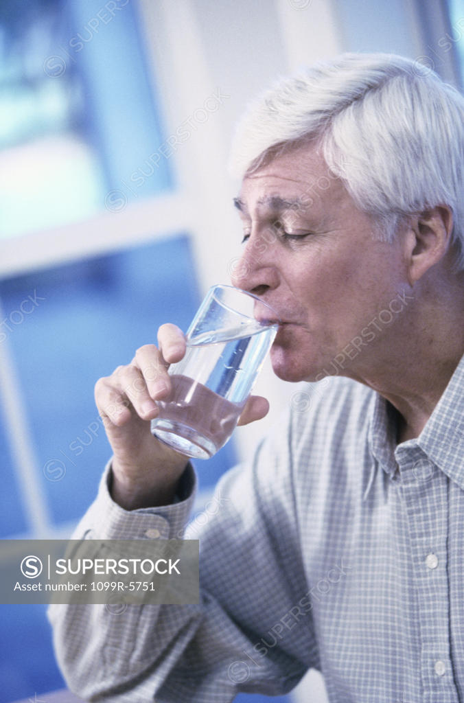 Stock Photo: 1099R-5751 Elderly man drinking a glass of water