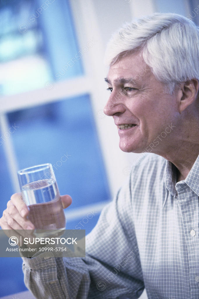 Stock Photo: 1099R-5754 Elderly man holding a glass of water
