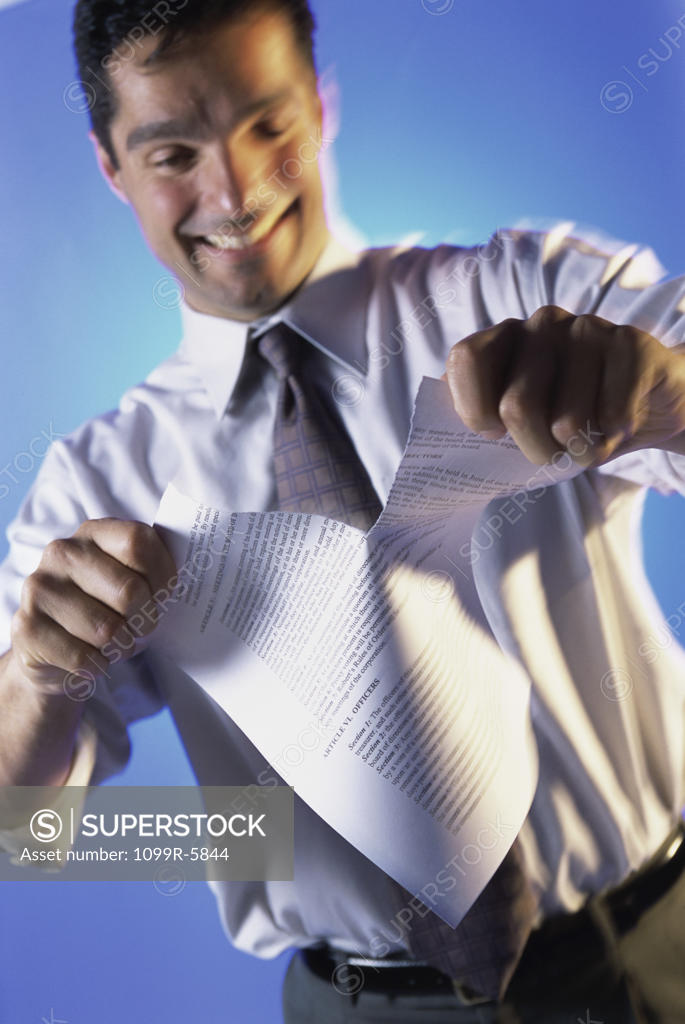 Stock Photo: 1099R-5844 Businessman tearing a sheet of paper
