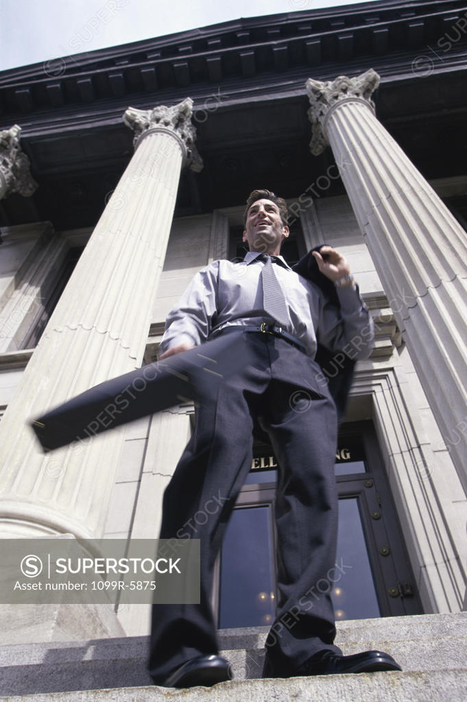 Stock Photo: 1099R-5875 Low angle view of a businessman standing on stairs