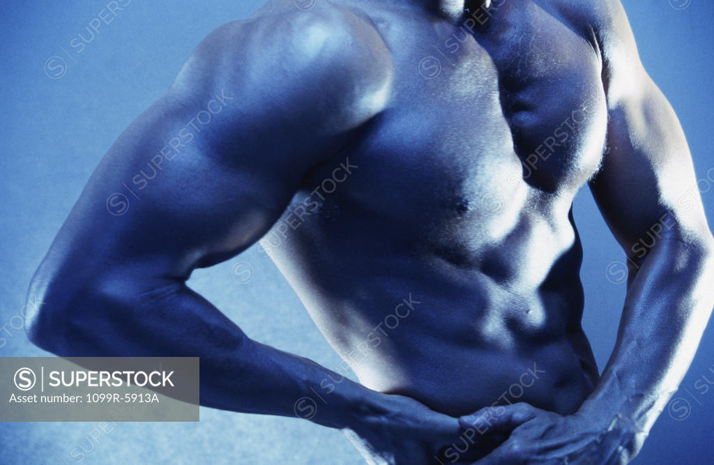 Stock Photo: 1099R-5913A Mid section view of a young man flexing his muscles