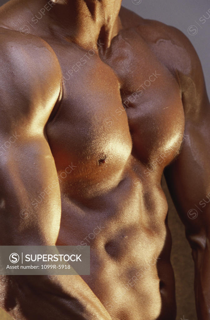 Stock Photo: 1099R-5918 Mid section view of a young man flexing his muscles