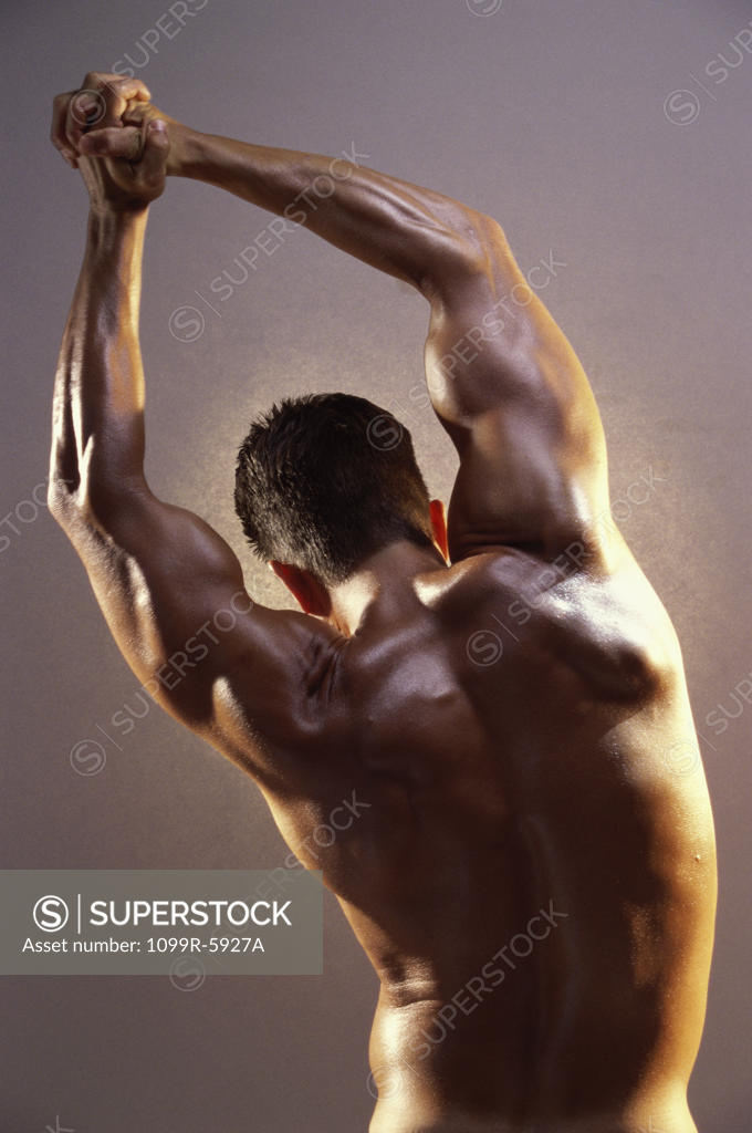 Stock Photo: 1099R-5927A Rear view of a young man flexing his muscles