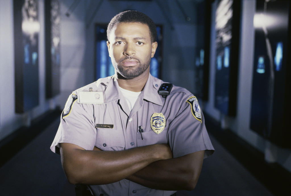 Portrait of a male security guard standing with his arms crossed