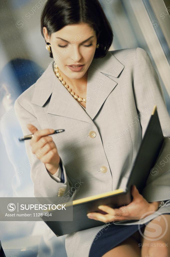 Stock Photo: 1128-464 Businesswoman holding a file and a pen