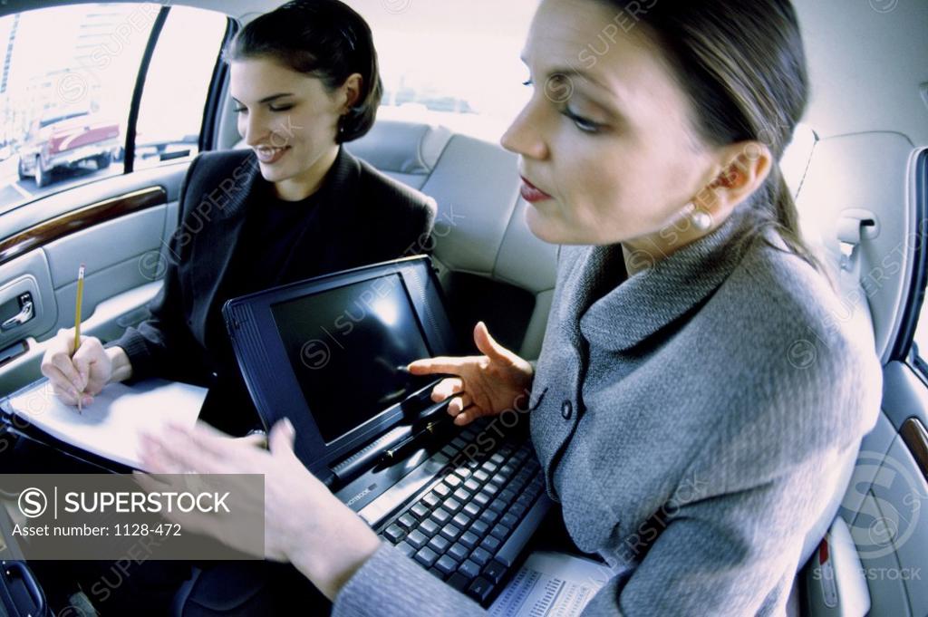Stock Photo: 1128-472 Two businesswomen having a discussion in a car