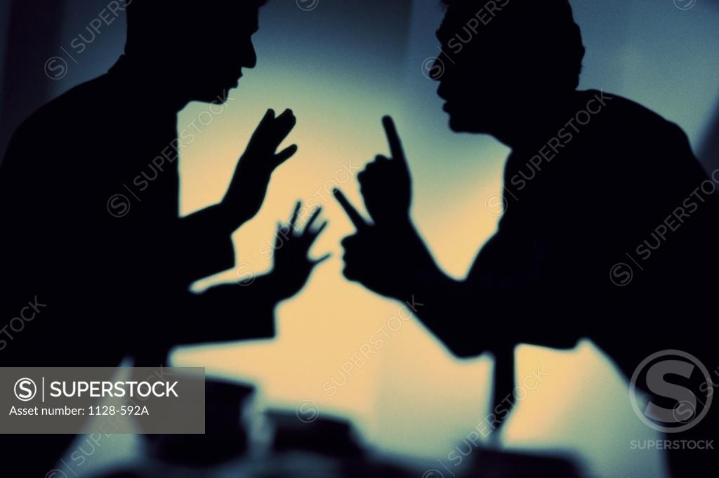 Stock Photo: 1128-592A Silhouette of two businessmen arguing in an office