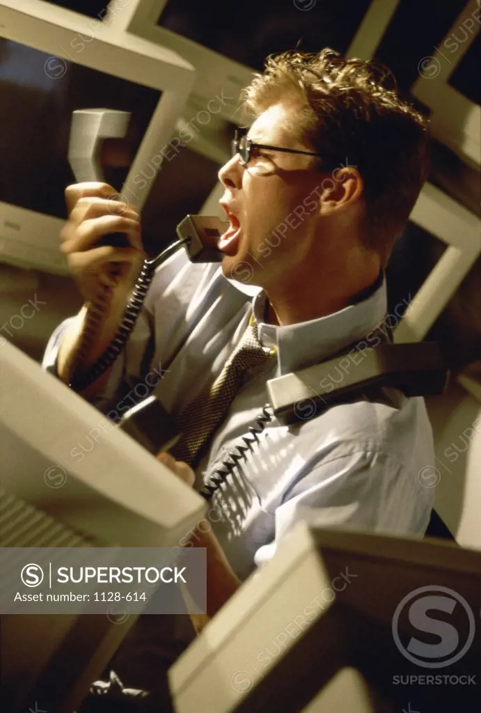 Side profile of a businessman shouting on the telephone