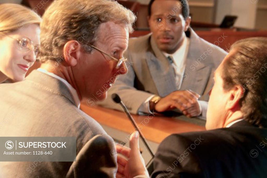 Stock Photo: 1128-640 Two businessmen and a businesswoman talking with a judge