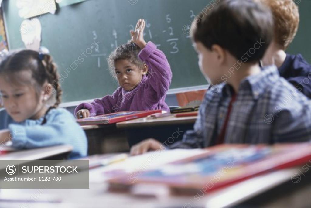 Stock Photo: 1128-780 Girl with her hand raised in a classroom
