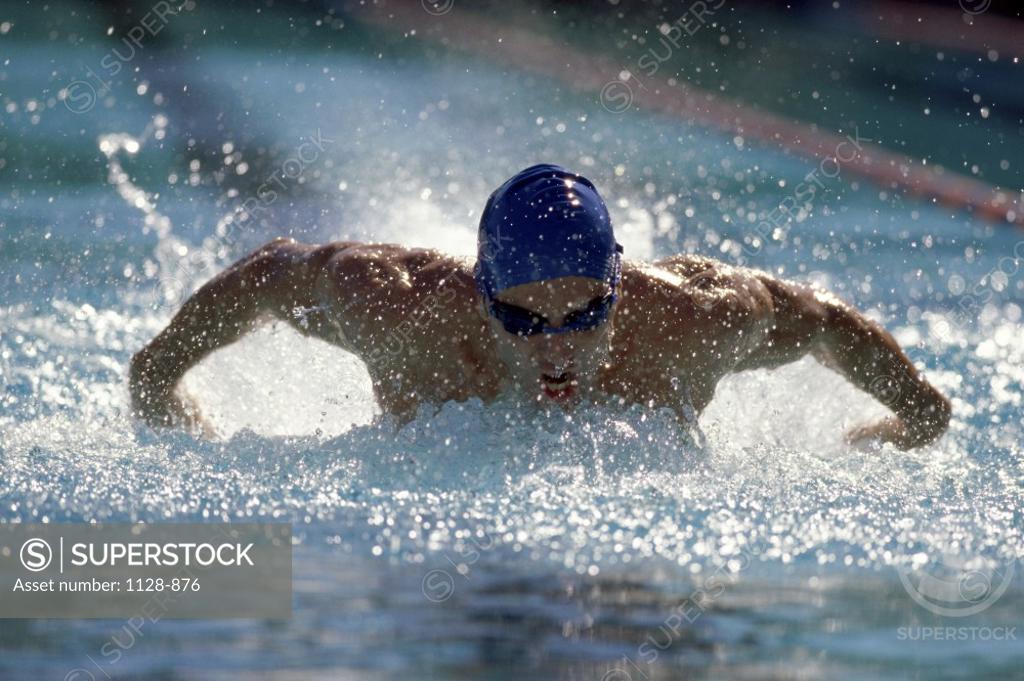 Stock Photo: 1128-876 Young man swimming the butterfly stroke