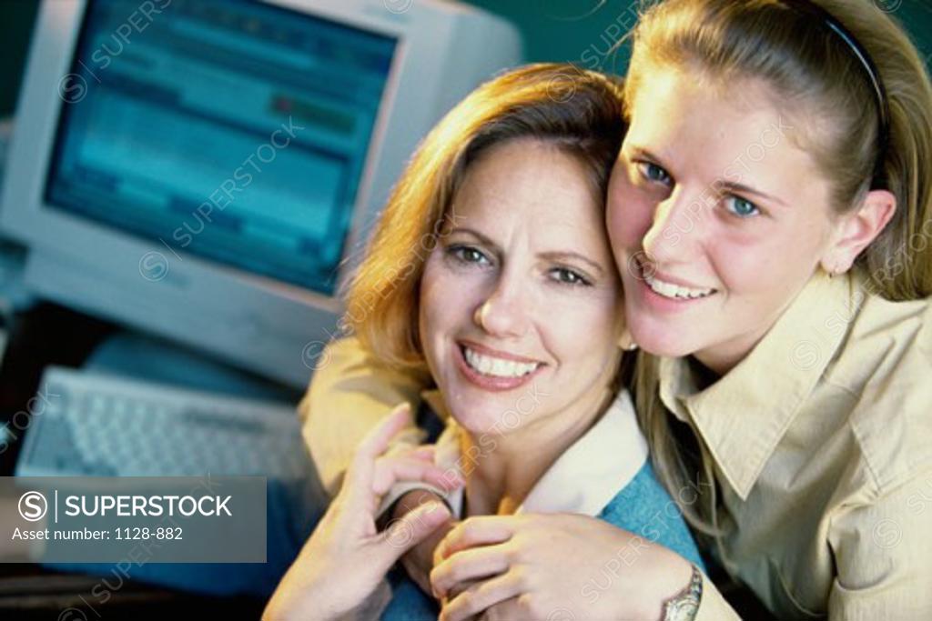 Stock Photo: 1128-882 Portrait of a teenage girl hugging her mother from behind and smiling