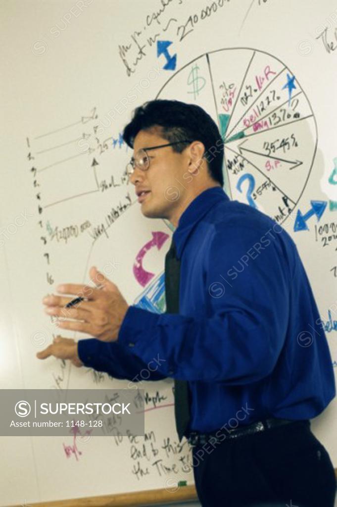 Stock Photo: 1148-128 Side profile of a businessman explaining a pie chart on a whiteboard