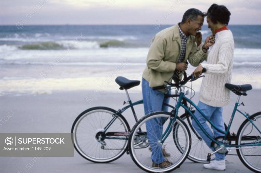Stock Photo: 1149-209 Mature couple on bicycles on the beach