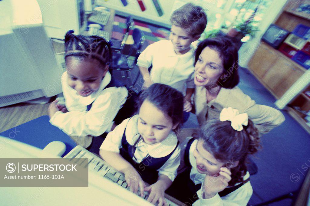 Stock Photo: 1165-101A Teacher helping her students with a computer