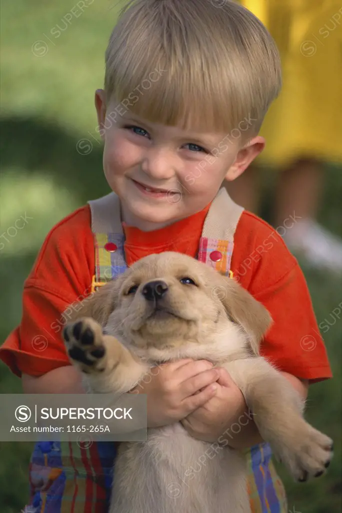 Portrait of a boy holding a puppy
