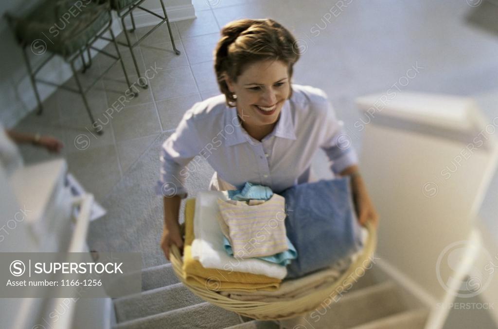 Stock Photo: 1166-1256 High angle view of a young woman carrying a laundry basket