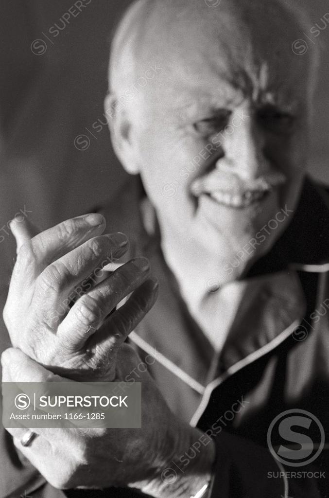 Stock Photo: 1166-1285 Senior man holding out his wrist