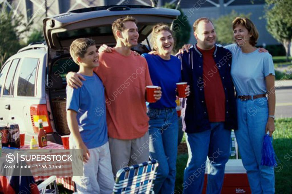 Stock Photo: 1166-1355C Group of people standing behind a vehicle at a picnic