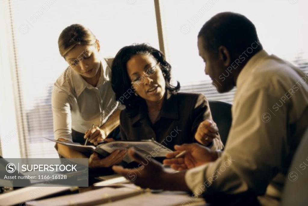 Stock Photo: 1166-1612B Two businesswomen and a businessman in an office