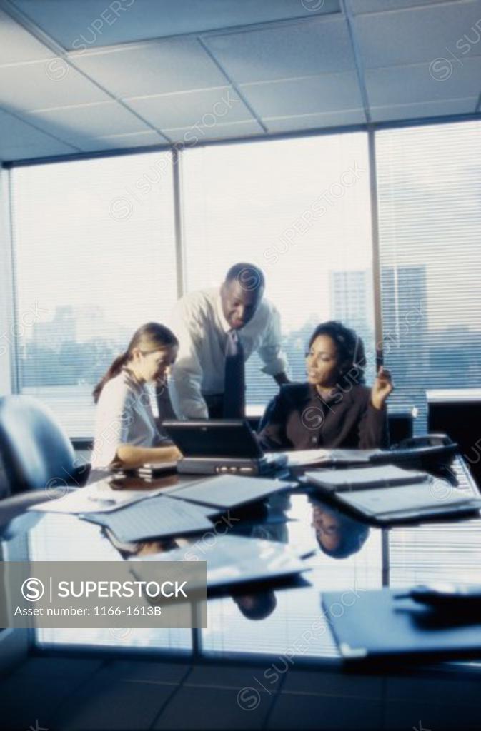 Stock Photo: 1166-1613B Three business executives working in an office