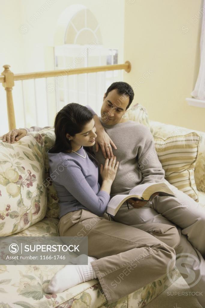 Stock Photo: 1166-1746 Mid adult couple sitting together on a couch