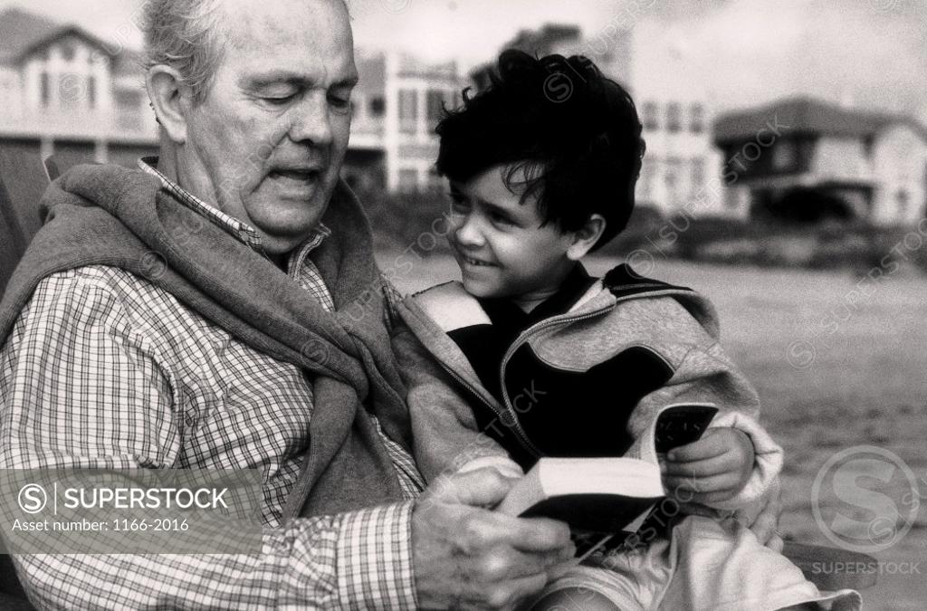 Stock Photo: 1166-2016 Grandfather reading a book with his grandson
