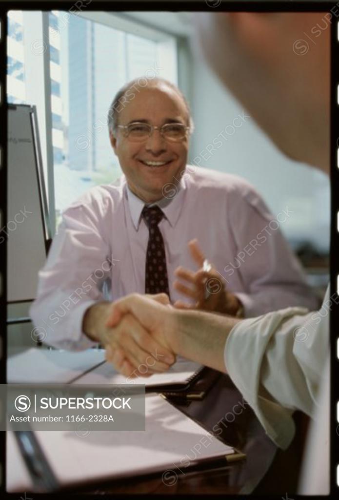 Stock Photo: 1166-2328A Two businessmen shaking hands in a meeting