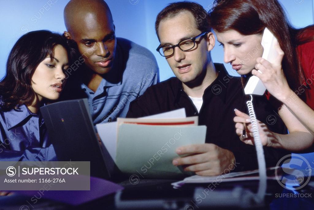 Stock Photo: 1166-276A Two businessmen and two businesswomen talking in an office
