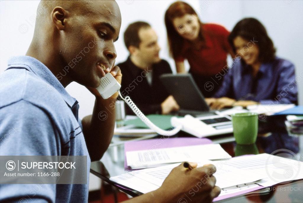 Stock Photo: 1166-288 Two businesswomen and two businessmen working in an office