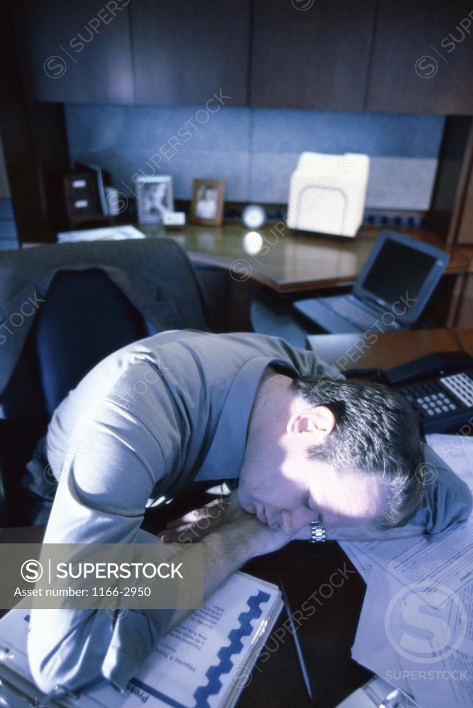 Stock Photo: 1166-2950 High angle view of a businessman resting his head on a desk