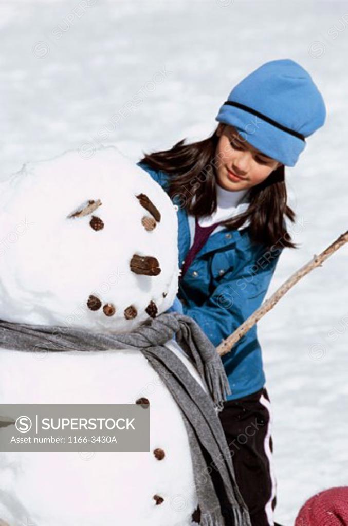 Stock Photo: 1166-3430A Girl making a snowman