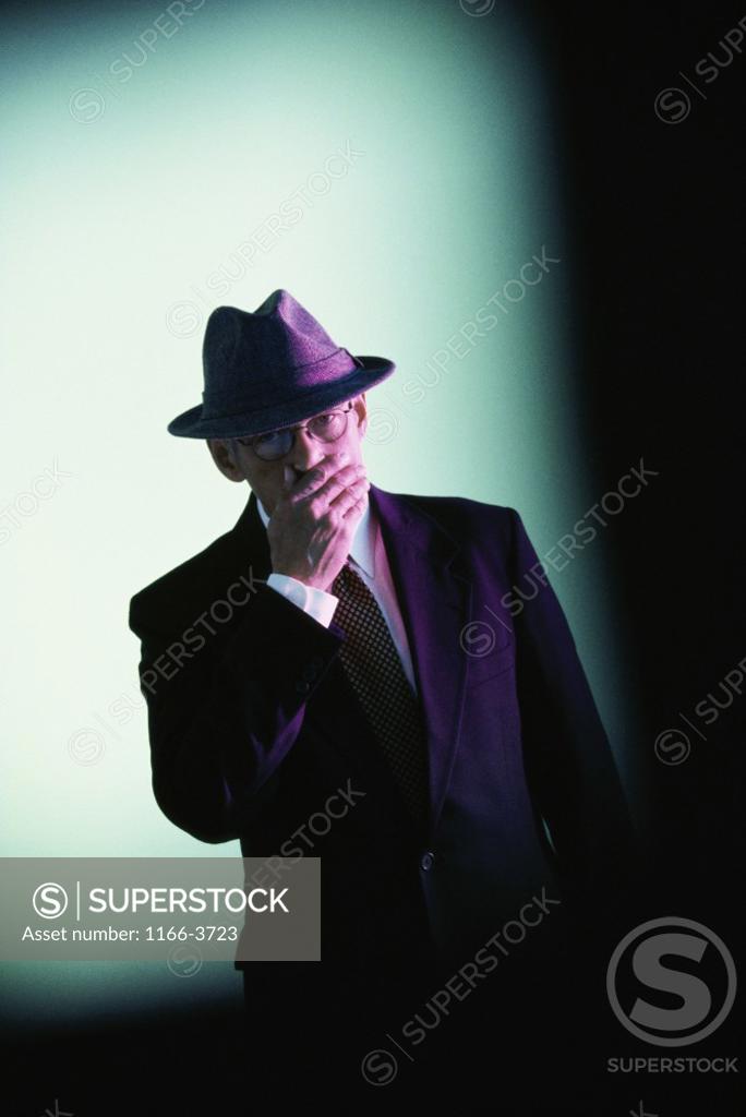 Stock Photo: 1166-3723 Businessman covering his mouth with his hand