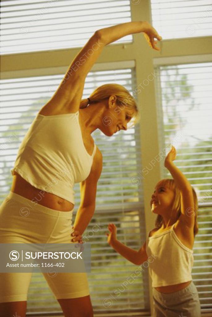 Stock Photo: 1166-402 Pregnant mother exercising with her daughter