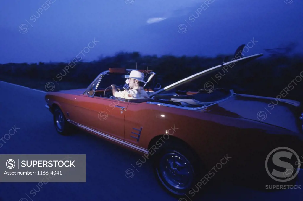 Side profile of a young man driving a car
