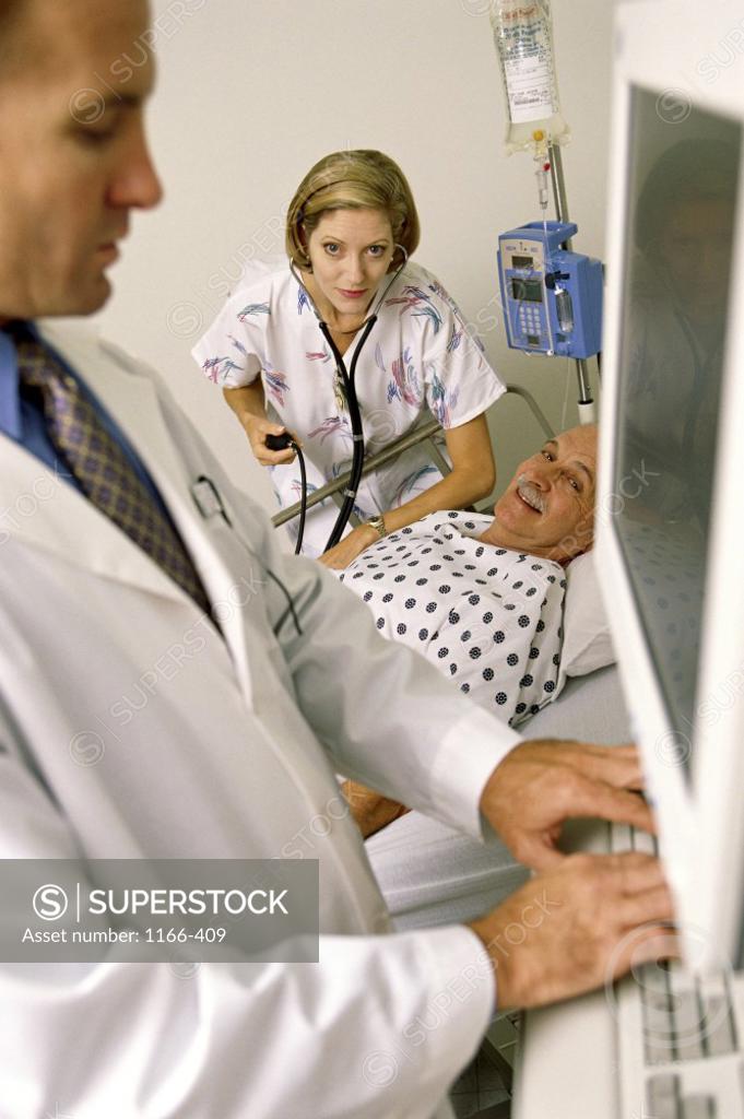 Stock Photo: 1166-409 Doctor using computer to monitor patient
