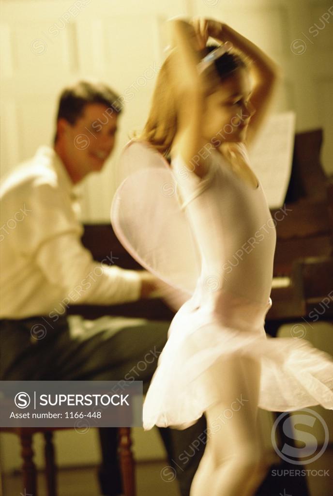 Stock Photo: 1166-448 Father playing the piano with his daughter dancing