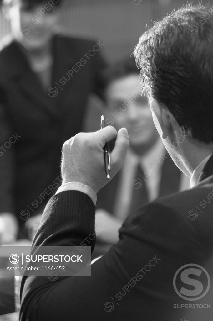 Stock Photo: 1166-452 Two businessmen and a businesswoman in an office