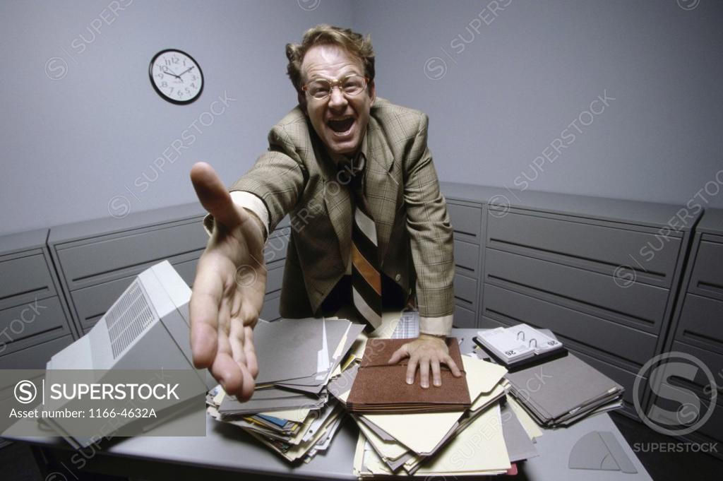 Stock Photo: 1166-4632A Businessman standing at a desk holding his hand out