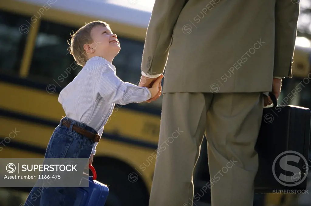 Father standing with his son at a bus stop