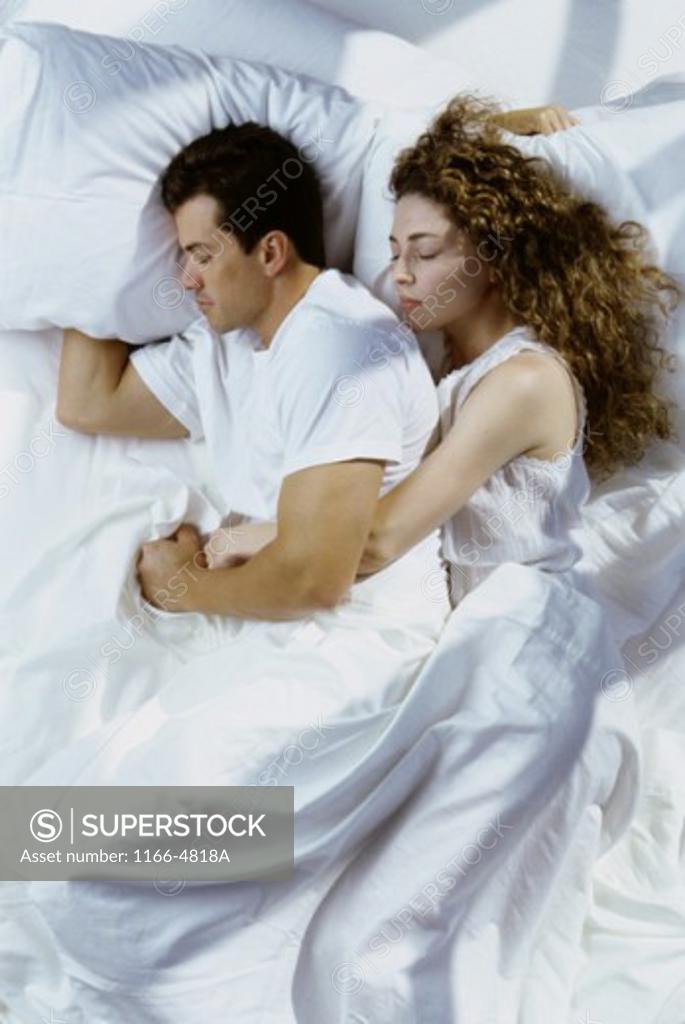 Stock Photo: 1166-4818A Mid adult couple sleeping on a bed