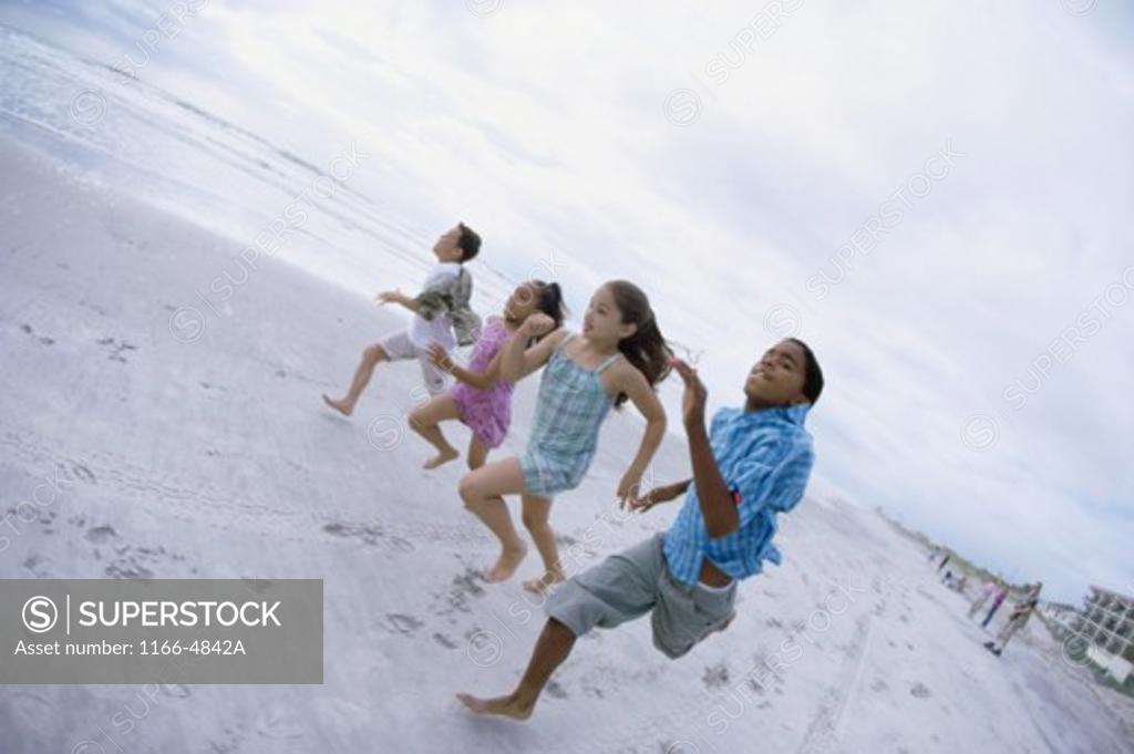 Stock Photo: 1166-4842A Two boys and two girls running on the beach