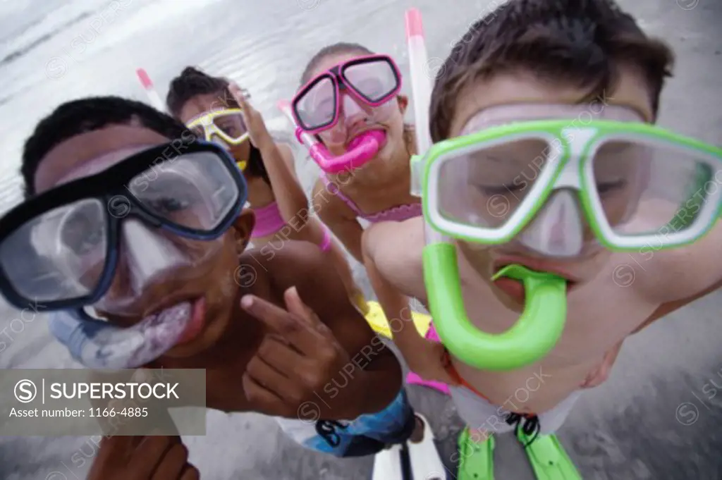Portrait of two boys and two girls wearing snorkels on the beach