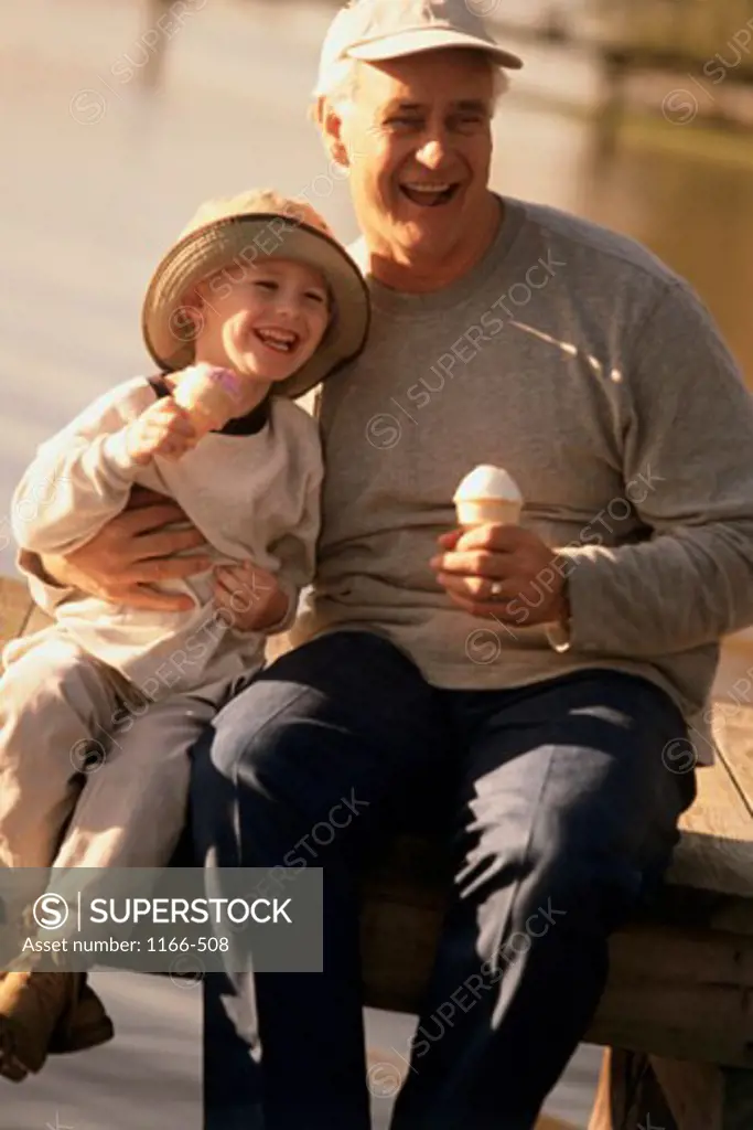 Grandfather sitting with his grandson holding ice cream cones