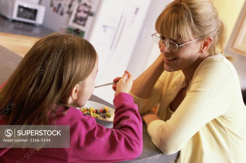 Stock Photo: 1166-5144 Daughter eating in front of her mother