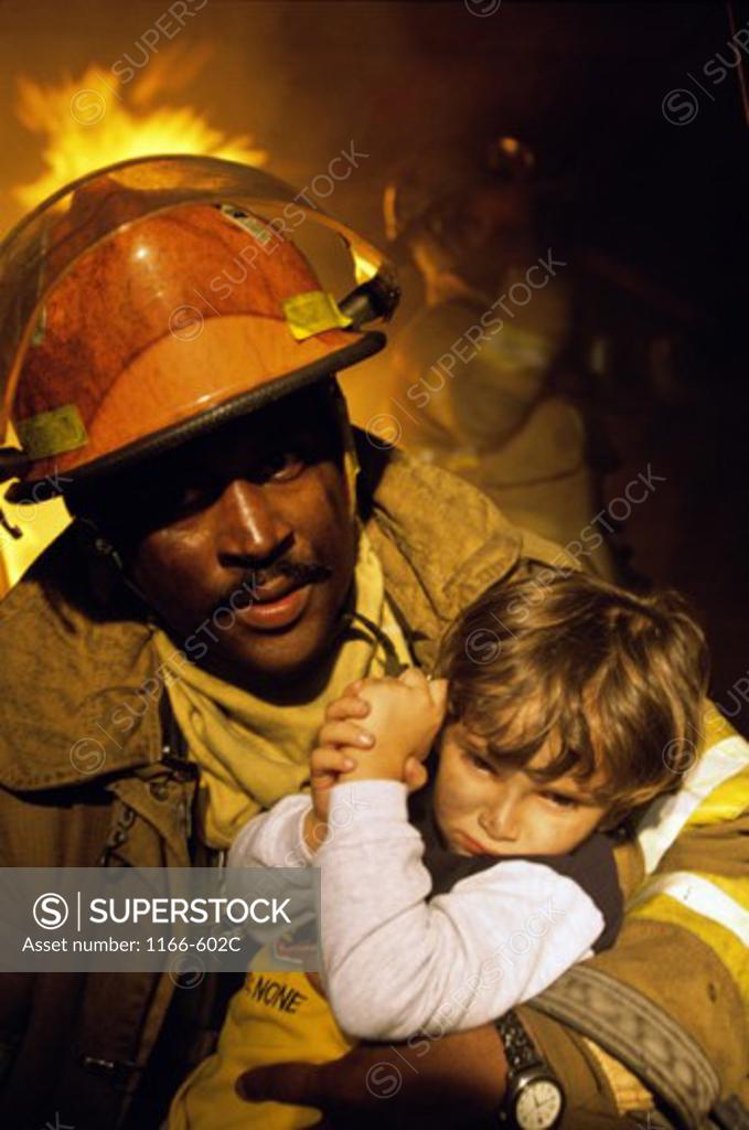 Stock Photo: 1166-602C Firefighter carrying a boy