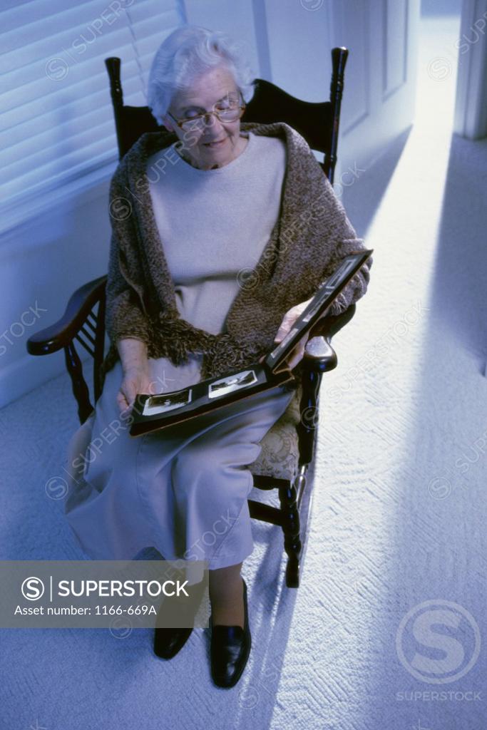 Stock Photo: 1166-669A Senior woman looking at a photo album