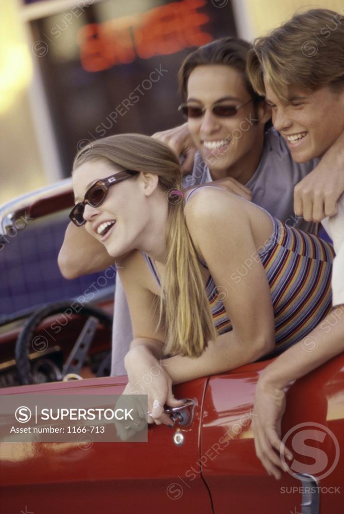 Stock Photo: 1166-713 Portrait of two teenage boys and a teenage girl sitting in a convertible car