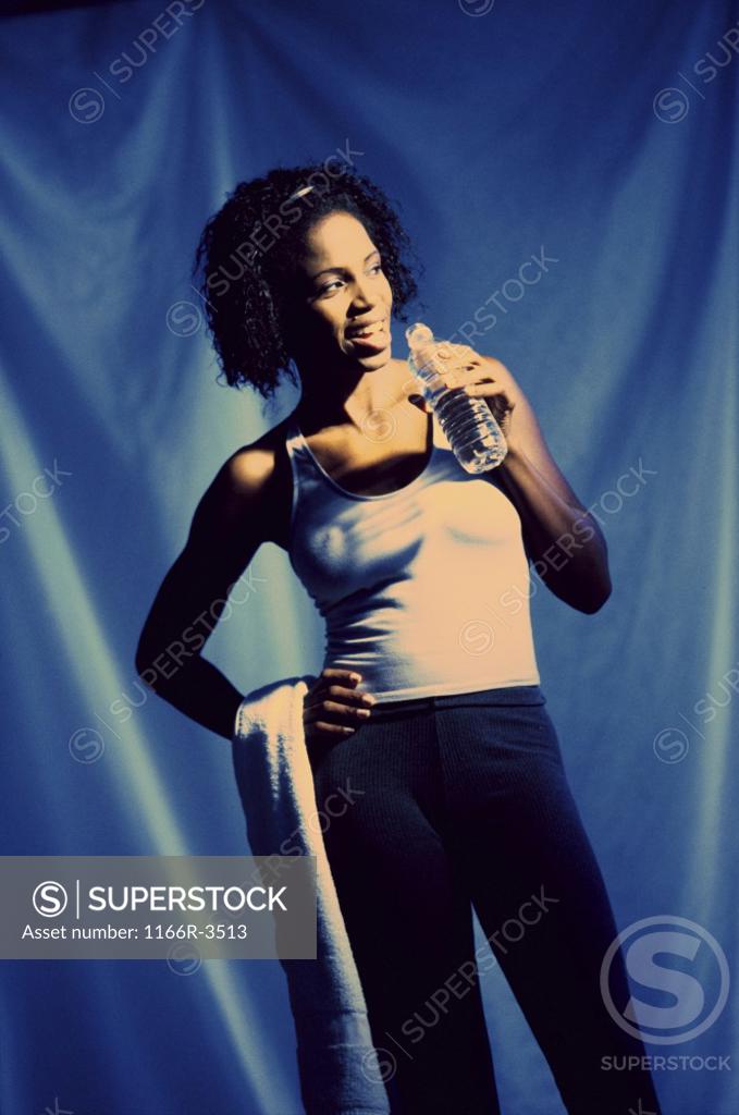 Stock Photo: 1166R-3513 Young woman holding a bottle of water and a towel